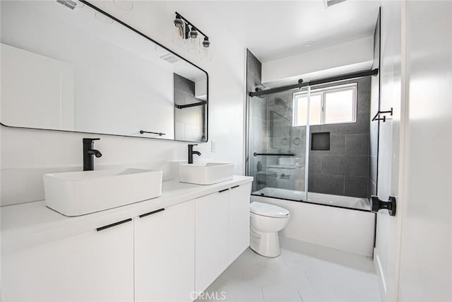 full bathroom with vanity, bath / shower combo with glass door, and toilet