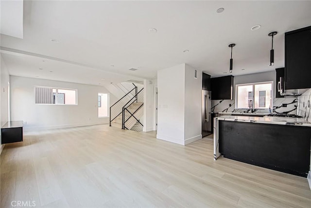 kitchen with plenty of natural light, sink, high end refrigerator, and light hardwood / wood-style floors