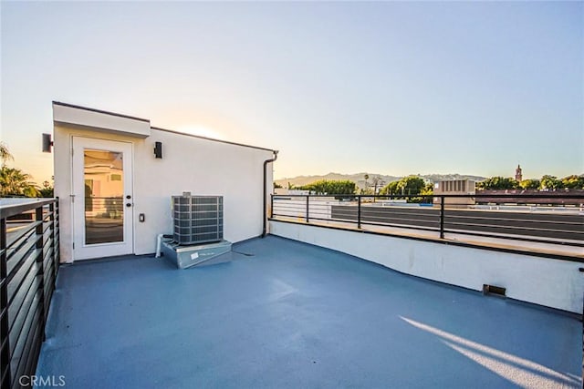 patio terrace at dusk with a balcony and central air condition unit