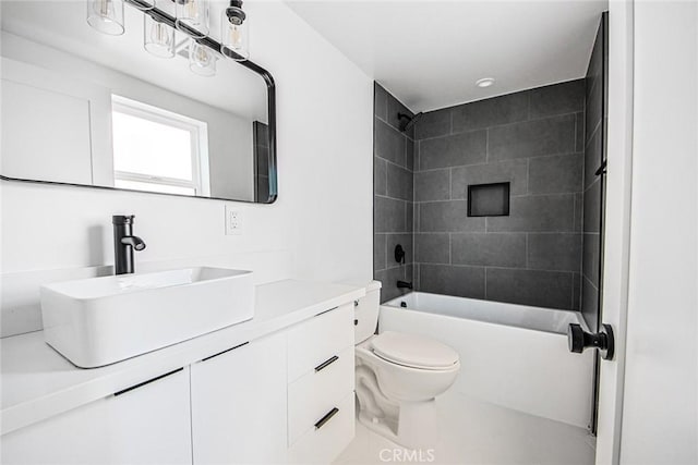 full bathroom featuring tiled shower / bath, vanity, and toilet