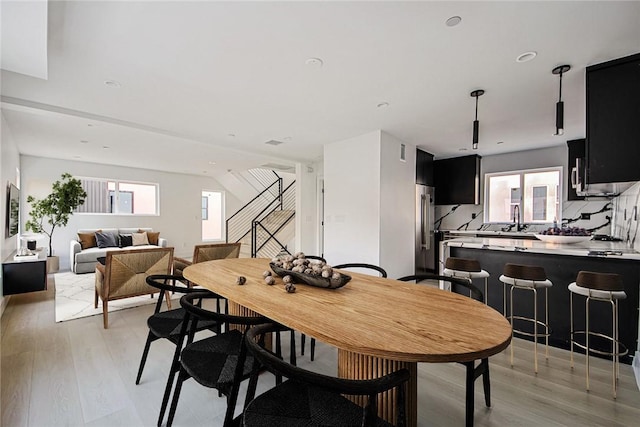 dining area featuring sink and light wood-type flooring