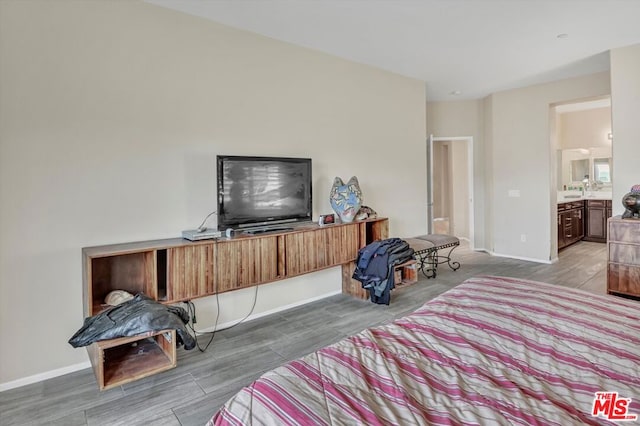 bedroom featuring hardwood / wood-style flooring and ensuite bathroom