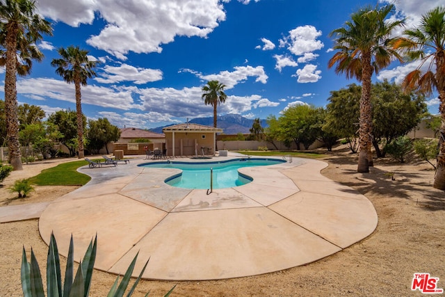 view of swimming pool featuring a patio area and a mountain view