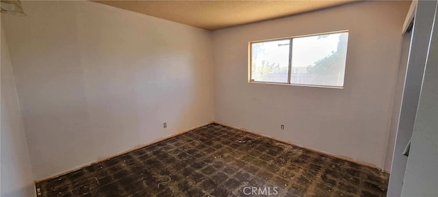 unfurnished room featuring a textured ceiling