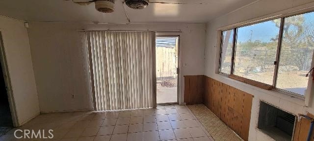 unfurnished sunroom with ceiling fan