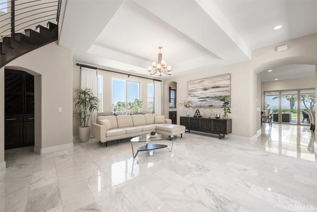 living room with a tray ceiling and an inviting chandelier