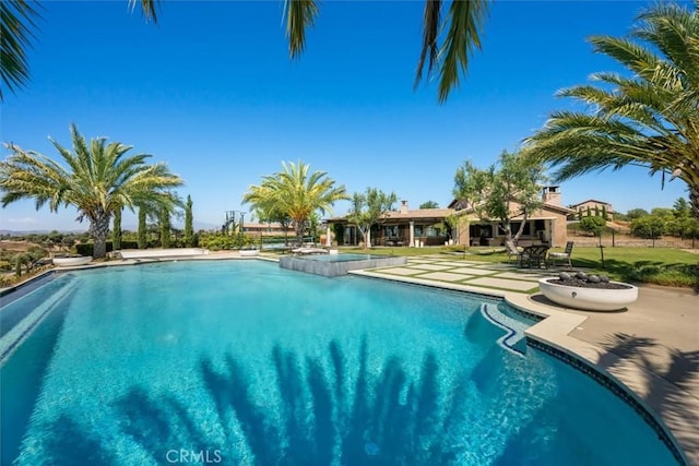 view of swimming pool featuring a jacuzzi and a patio