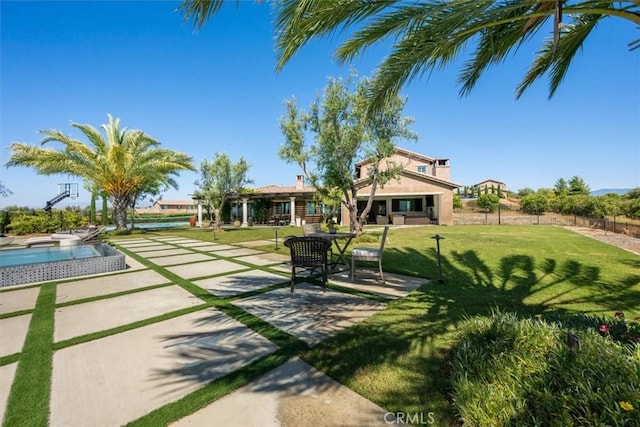 view of community featuring a lawn, a patio area, and a pool