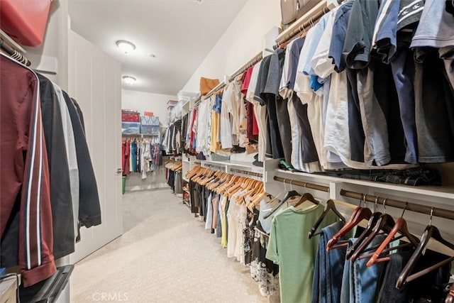 walk in closet featuring light carpet