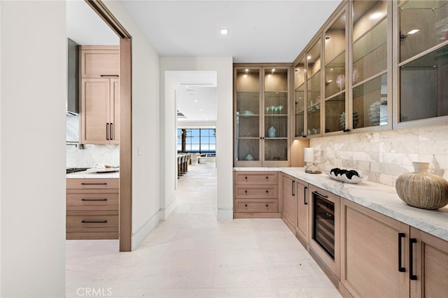 kitchen featuring beverage cooler, light stone countertops, backsplash, and light tile patterned floors