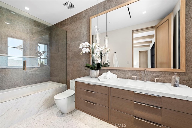 full bathroom featuring vanity, tile walls, toilet, and visible vents