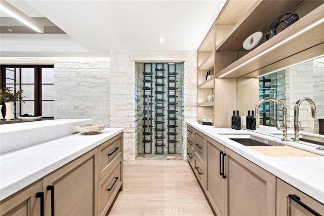 kitchen with light hardwood / wood-style floors, light brown cabinets, and sink