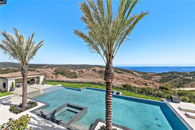 view of swimming pool featuring a water view and a patio area