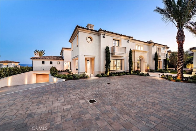 mediterranean / spanish house featuring a balcony and stucco siding