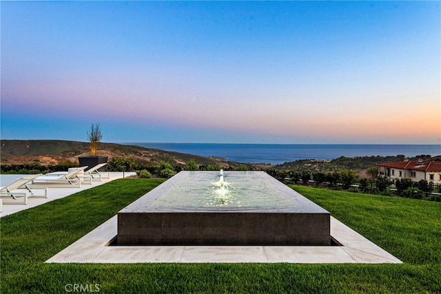 surrounding community featuring a water view and a lawn