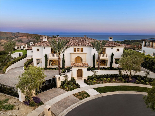 mediterranean / spanish-style home featuring a balcony and a water view