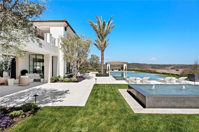 view of yard featuring a patio, pool water feature, a balcony, and outdoor lounge area