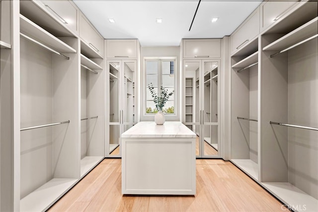 walk in closet with light wood finished floors