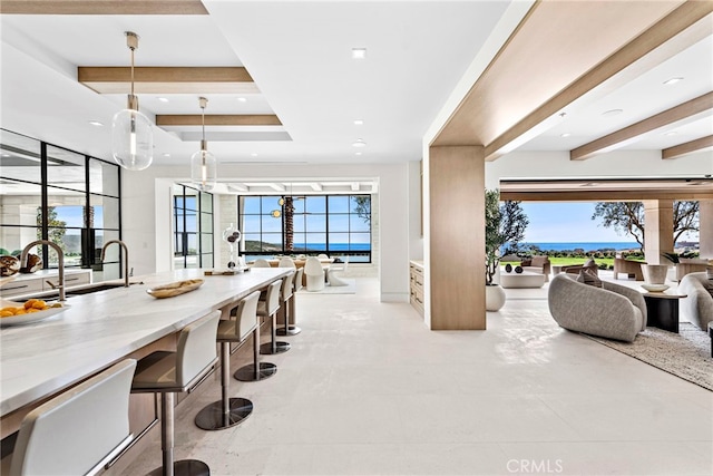 dining space with light tile patterned flooring, sink, and beam ceiling