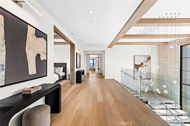 hall with light hardwood / wood-style floors and beam ceiling