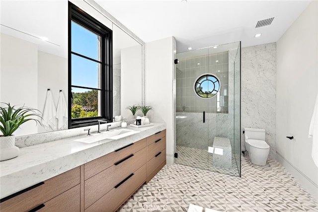 bathroom featuring visible vents, vanity, toilet, and a shower stall