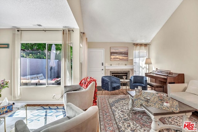 living room featuring a high end fireplace, hardwood / wood-style floors, and a textured ceiling