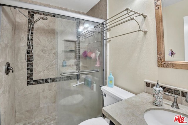 bathroom featuring vanity, a shower with shower door, and toilet