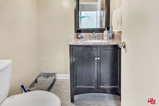 bathroom featuring hardwood / wood-style flooring, vanity, and toilet