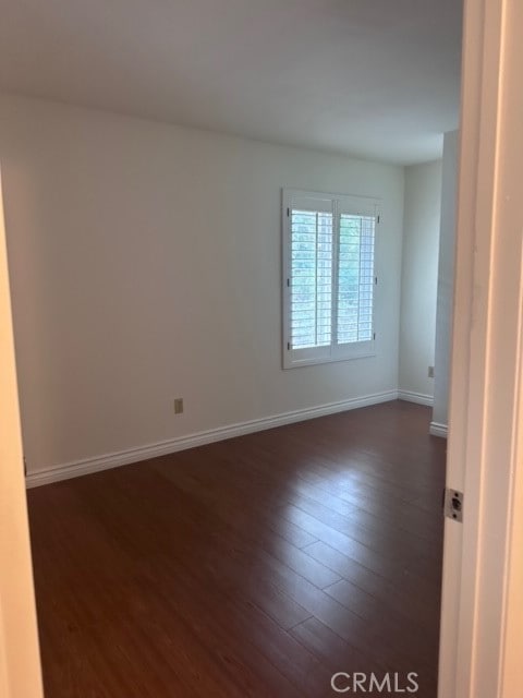 spare room with dark hardwood / wood-style floors