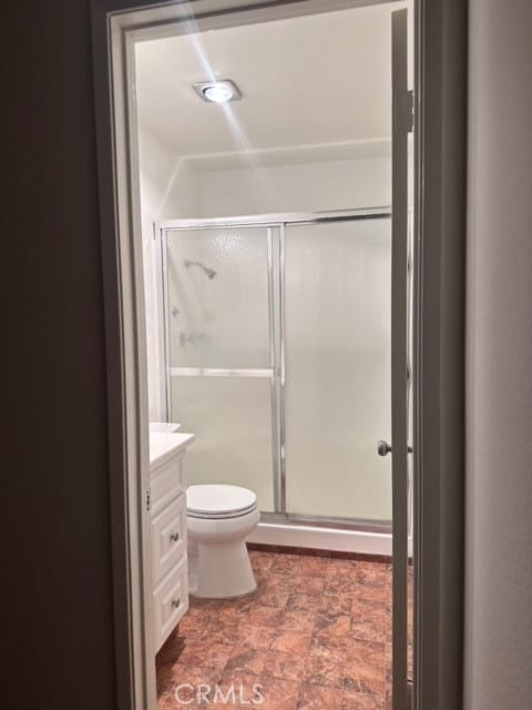 bathroom featuring vanity, tile patterned floors, a shower with door, and toilet