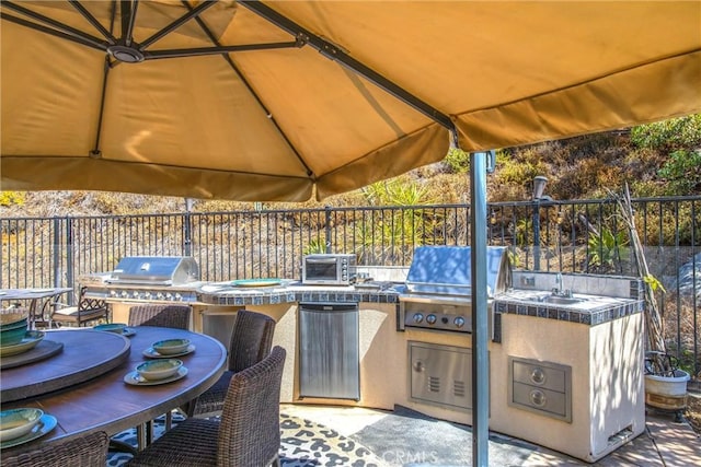 view of patio / terrace featuring a grill and an outdoor kitchen