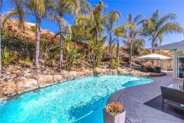 view of pool featuring pool water feature and a patio