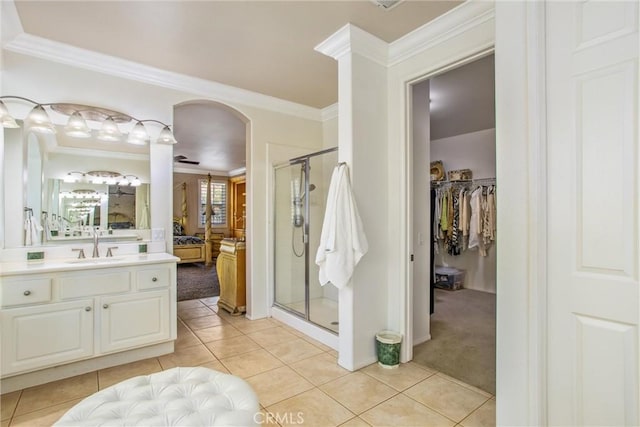 bathroom with ceiling fan, walk in shower, tile patterned floors, vanity, and ornamental molding