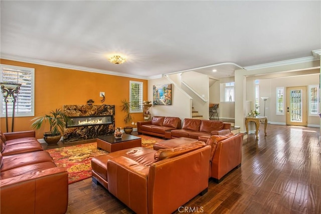 living room with a high end fireplace, dark hardwood / wood-style floors, and ornamental molding