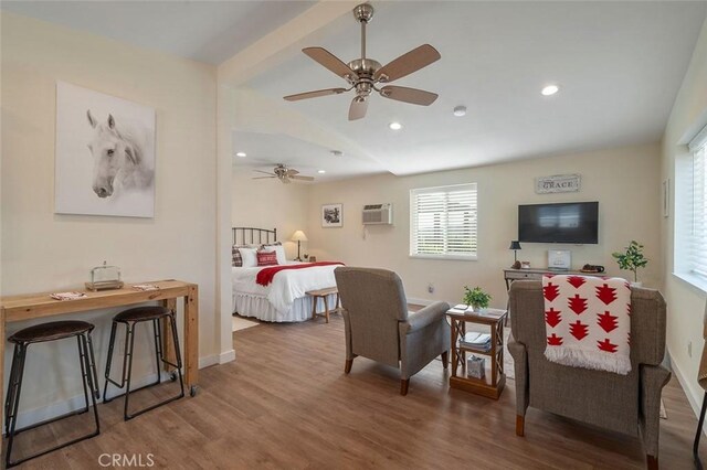 bedroom featuring hardwood / wood-style floors, ceiling fan, and a wall mounted AC