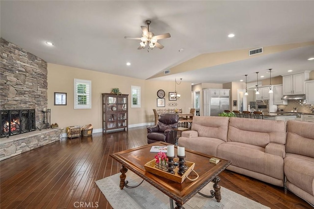 living room featuring a fireplace, lofted ceiling, ceiling fan, and dark wood-type flooring