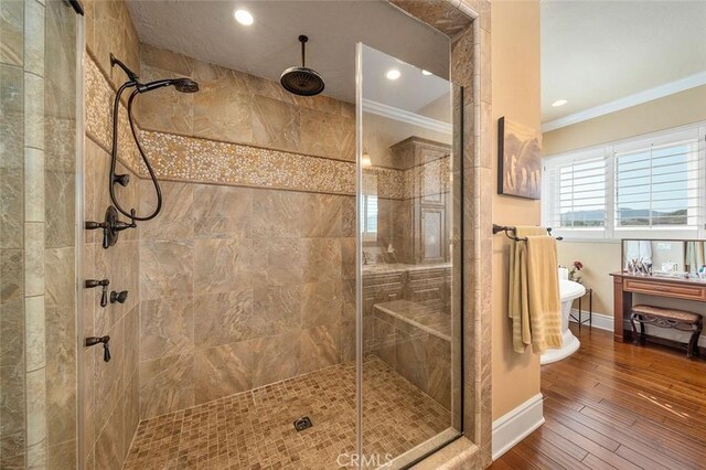 bathroom featuring hardwood / wood-style flooring, a shower with door, and crown molding