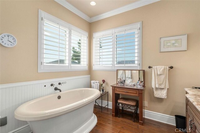 bathroom with hardwood / wood-style floors, plenty of natural light, a bathing tub, and crown molding