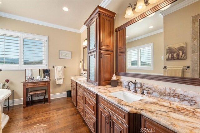 bathroom featuring vanity, a tub to relax in, wood-type flooring, and crown molding