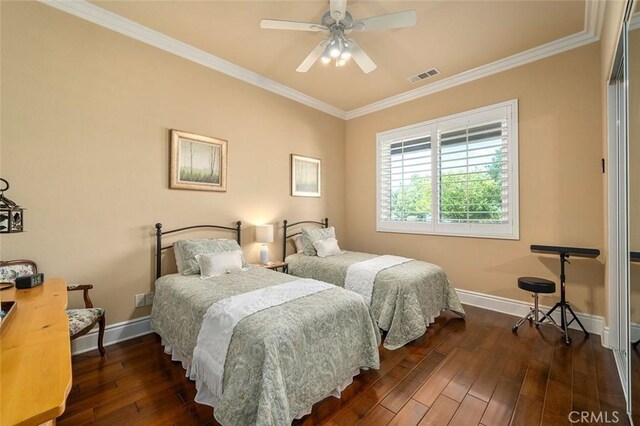 bedroom with dark hardwood / wood-style floors, ceiling fan, and ornamental molding