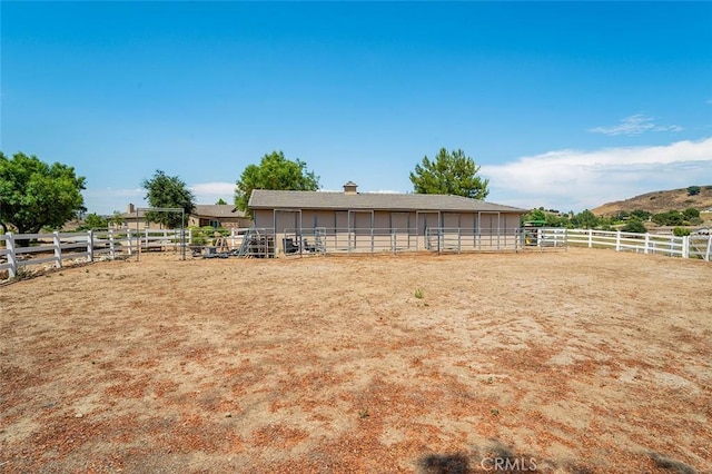 view of yard with an outbuilding and a rural view