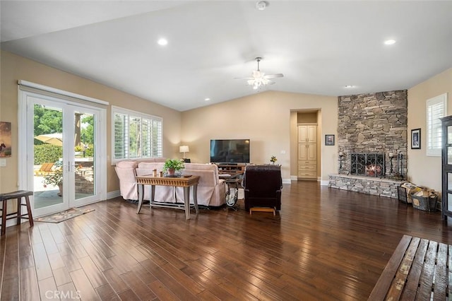 living room with a fireplace, vaulted ceiling, ceiling fan, and dark wood-type flooring