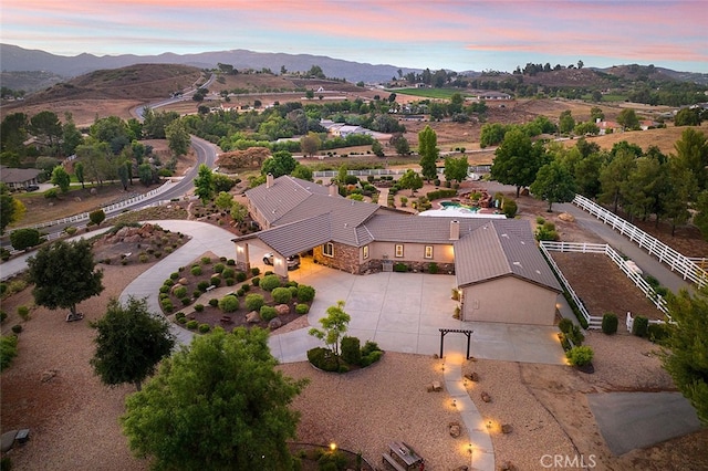 aerial view at dusk featuring a mountain view