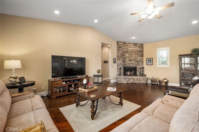 living room with a stone fireplace, ceiling fan, dark hardwood / wood-style flooring, and lofted ceiling