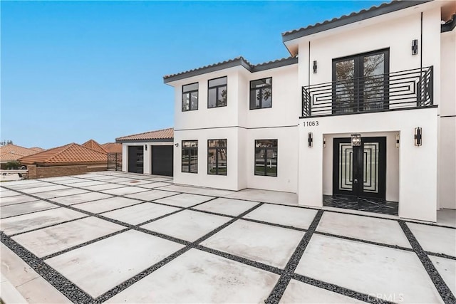 back of house featuring a garage and a balcony