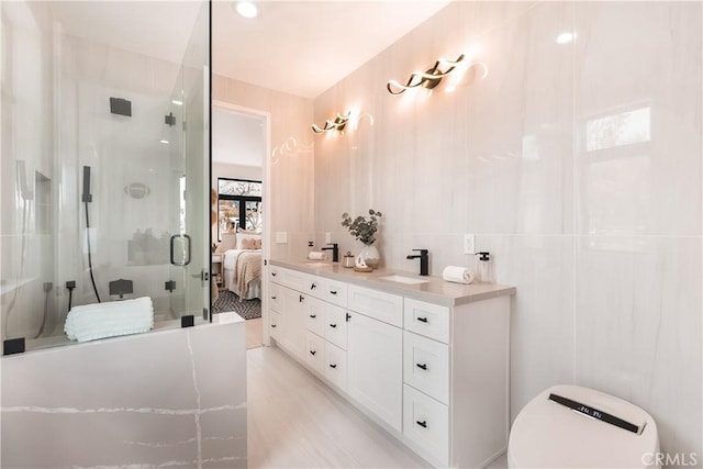 bathroom featuring tile walls, vanity, and a shower with shower door