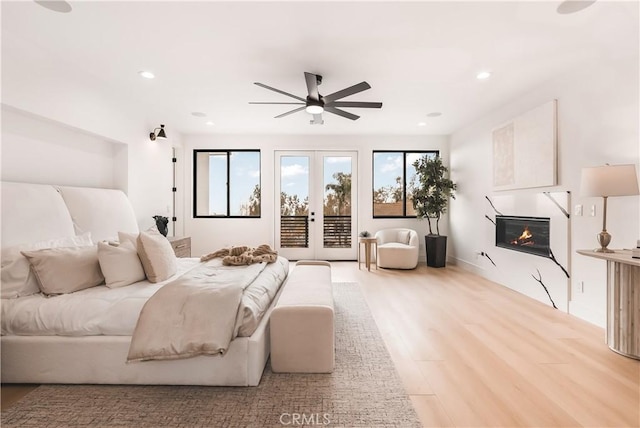 bedroom featuring ceiling fan, access to exterior, light hardwood / wood-style floors, and french doors