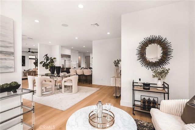 living room with ceiling fan and light wood-type flooring