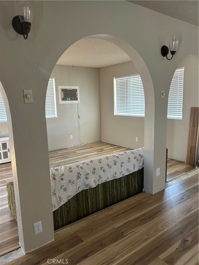 interior space with a textured ceiling and hardwood / wood-style floors