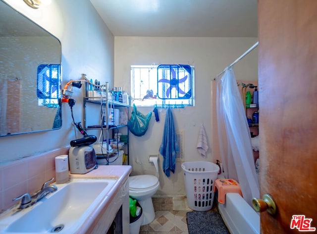 full bathroom featuring tile patterned flooring, backsplash, shower / bathtub combination with curtain, toilet, and vanity